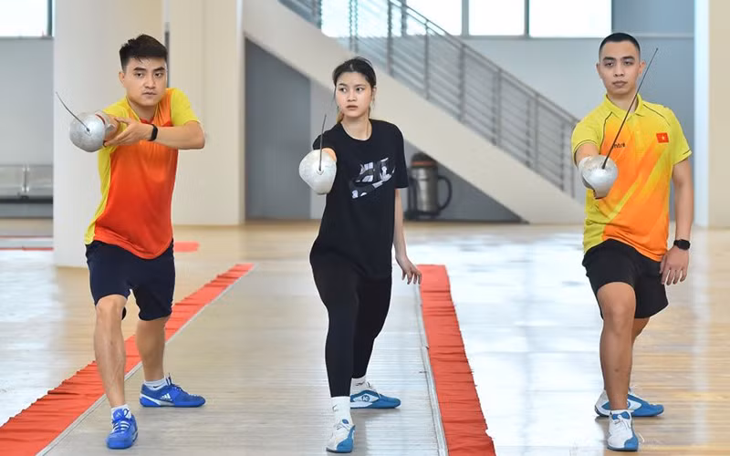 Vận động viên Hà Thanh An (người bên trái) hướng dẫn đồng đội nội dung kiếm chém chuẩn bị cho SEA Games 31. (Ảnh Mỹ Hà)