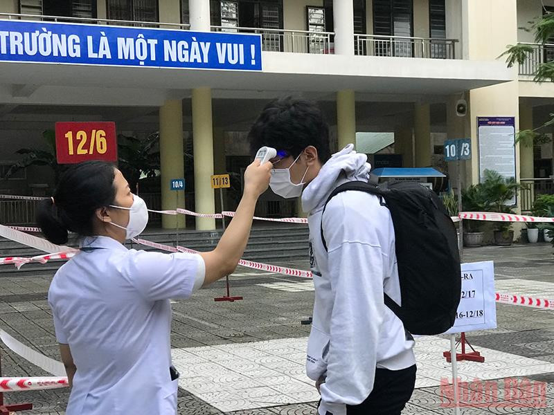Học sinh được đo thân nhiệt trước khi vào lớp. Học sinh khối 12 tại Đà Nẵng ngày trở lại trường -0