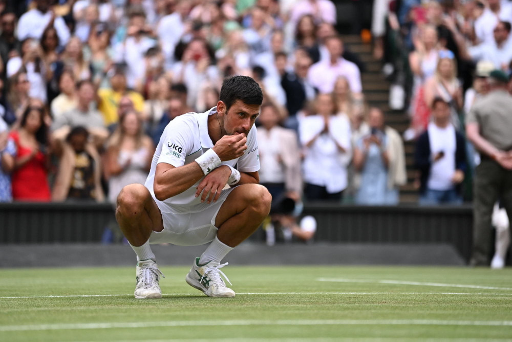 Màn nếm cỏ ăn mừng quen thuộc của Djokovic sau chiến thắng lịch sử ở chung kết Wimbledon 2021. (Ảnh: Wimbledon) Djokovic lập kỷ lục giành 20 danh hiệu Grand Slam danh giá -0