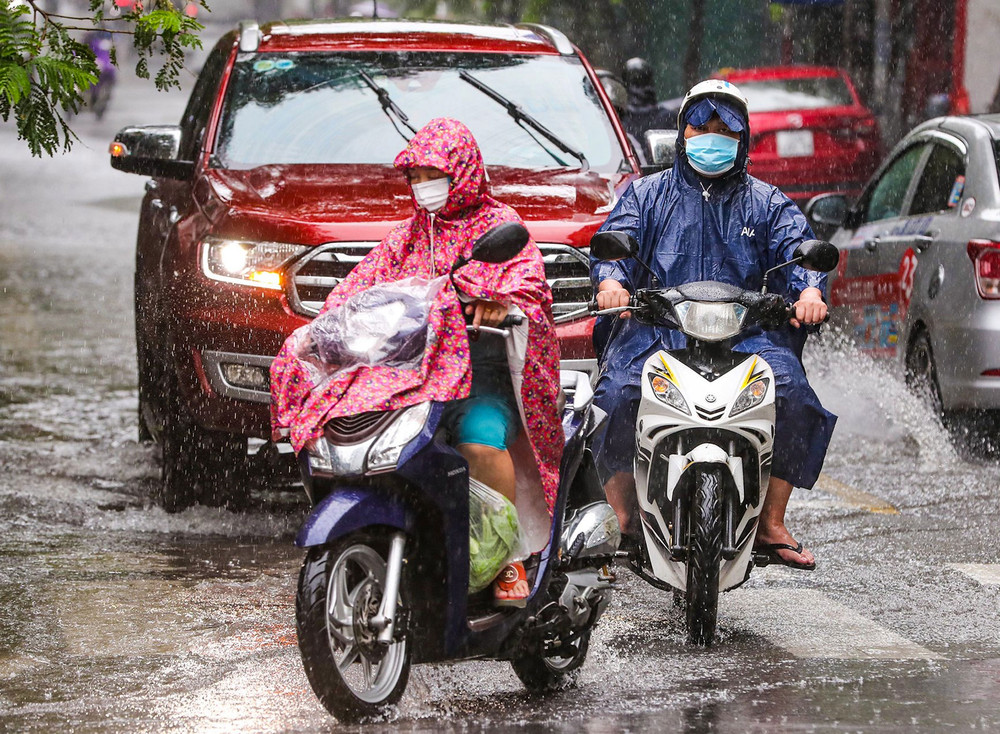 Mưa lớn kèm gió giật mạnh khiến nhiều người đi xe máy di chuyển khó khăn. Mưa lớn giải nhiệt cho Hà Nội sau chuỗi ngày nắng nóng -0