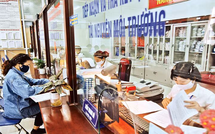 Cán bộ Bộ phận một cửa UBND quận Bắc Từ Liêm giải quyết thủ tục hành chính cho người dân. Ảnh: ANH VŨ
