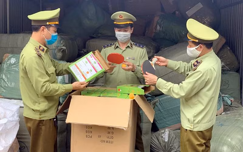 Lực lượng Quản lý thị trường tỉnh Lạng Sơn kiểm tra số hàng nghi nhập lậu tại Bưu cục Tân Thanh. (Ảnh BÙI NỤ)