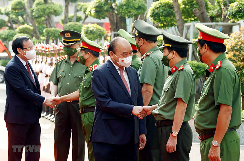 Chủ tịch nước Nguyễn Xuân Phúc, Bộ trưởng Công an Tô Lâm và Bí thư Thành ủy Thành phố Hồ Chí Minh Nguyễn Văn Nên với các lãnh đạo Công an Thành phố Hồ Chí Minh. (Ảnh: Thống Nhất/TTXVN)