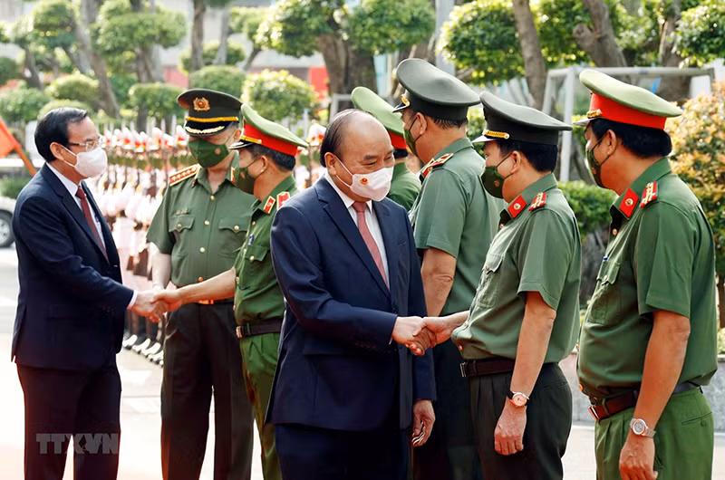 Chủ tịch nước Nguyễn Xuân Phúc, Bộ trưởng Công an Tô Lâm và Bí thư Thành ủy Thành phố Hồ Chí Minh Nguyễn Văn Nên với các lãnh đạo Công an Thành phố Hồ Chí Minh. (Ảnh: Thống Nhất/TTXVN)
