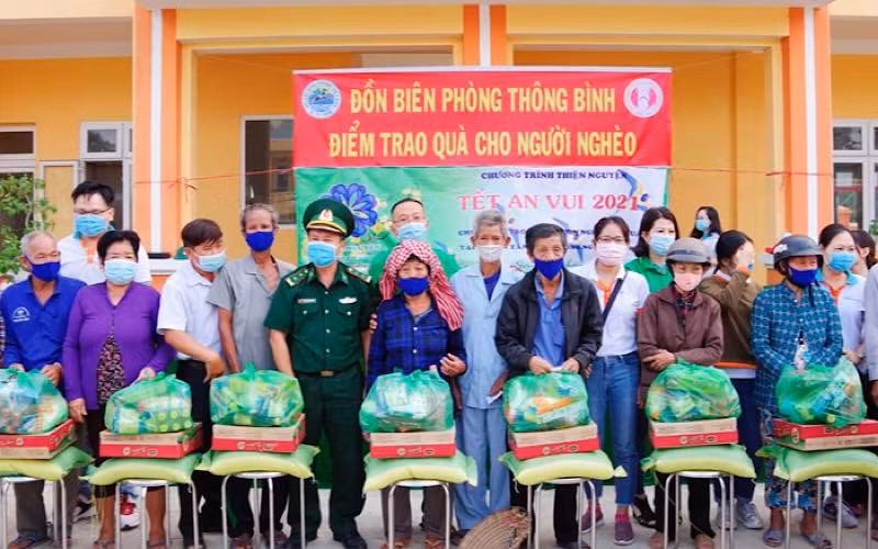 Đại diện đoàn thiện nguyện, địa phương và Đồn Biên phòng Thông Bình trao quà cho hộ nghèo. (Ảnh: Phú Quý)