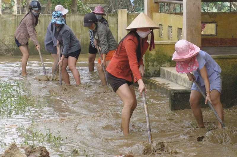 Các cô giáo vùng lũ Quảng Ninh (Quảng Bình) cào bùn non, làm sạch trường để đón học sinh.