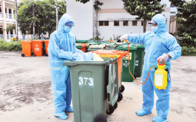 Công nhân Công ty Môi trường đô thị tiến hành khử khuẩn rác thải y tế liên quan dịch Covid-19.