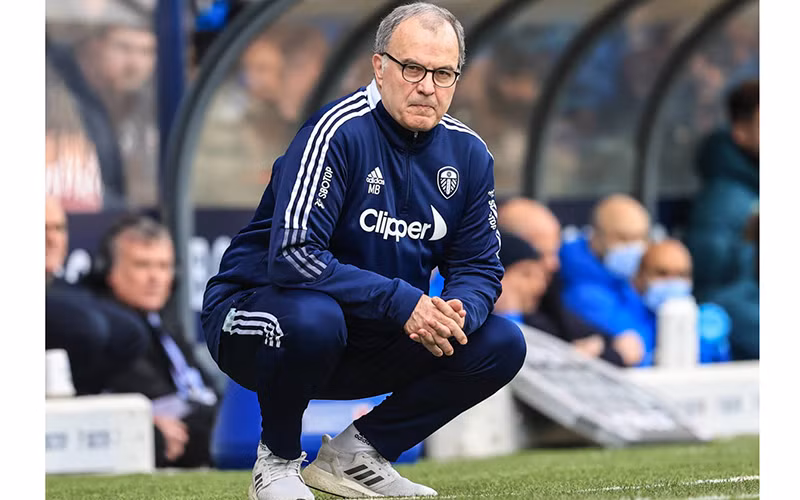 Marcelo Bielsa và dáng ngồi đặc trưng trên đường pitch. (Ảnh: SportIllustrated)