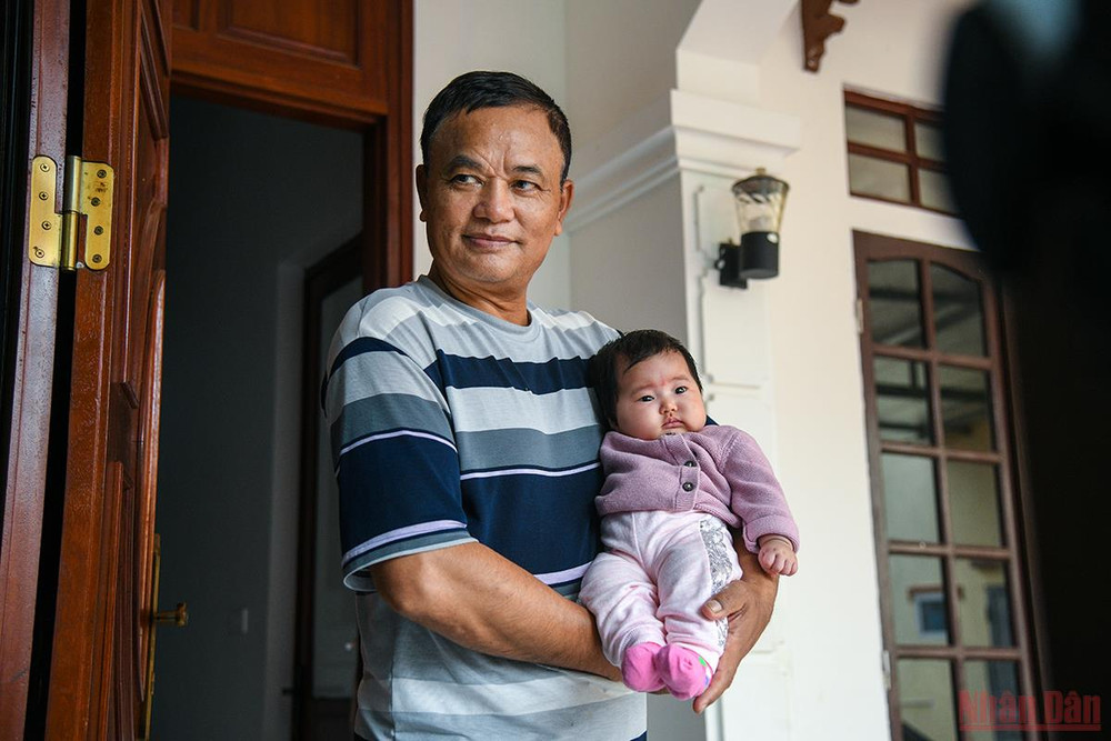 Ông Lê Văn Cừ, âm thầm bế đứa cháu nội mới 2 tháng tuổi ra 1 góc để cả nhà nghỉ ngơi sau chuyến đi dài. (Ảnh: THÀNH ĐẠT) Đồng bào trở về từ Ukraine: Chuyến hồi hương hạnh phúc nhất -0