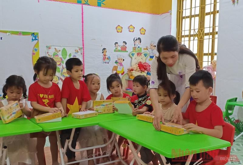 Cô và trò Trường mầm non Xuân La bên bàn, ghế và đồ dùng học tập mới được Báo Nhân Dân hỗ trợ. 