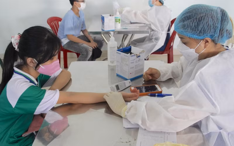 Các em được khám sàng lọc trước khi tiêm vaccine.