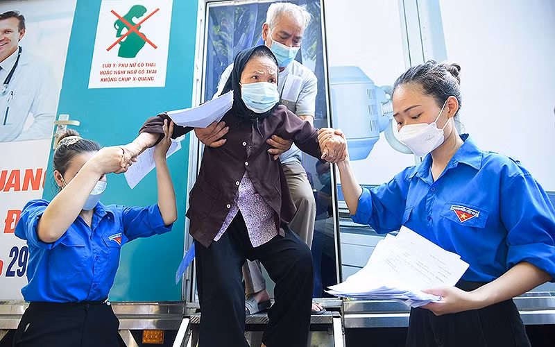 Đoàn viên, thanh niên tình nguyện hỗ trợ người dân khám bệnh tại chương trình. (Ảnh: Viết Niệm)