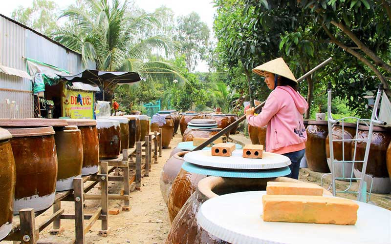 Chị Phan Thị Kim Diệu tất bật bên các lu khạp ủ cá của gia đình. Ảnh: HỮU NGHĨA Nâng cao quyền năng kinh tế cho phụ nữ -0