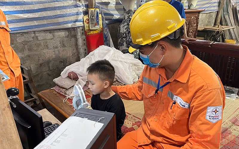 Các kỹ sư EVN Hà Nội vận chuyển thiết bị điện tử đến khu dân cư có hoàn cảnh khó khăn. 