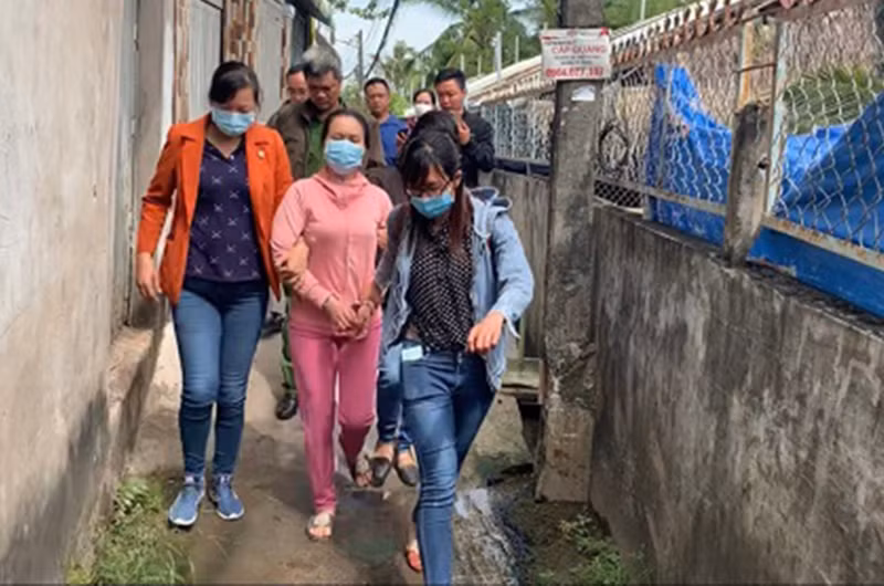 Đối tượng Lê Thị Bình (ở giữa, áo hồng) khi bị bắt. (Ảnh: Công an cung cấp)