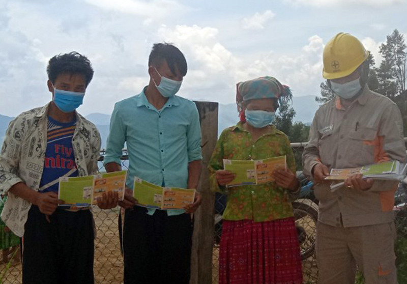 Công nhân điện lực Sơn La phát tờ rơi hướng dẫn cách sử dụng điện tiết kiệm cho các hộ bản Làng Sáng. Điện về sáng bản vùng cao -0