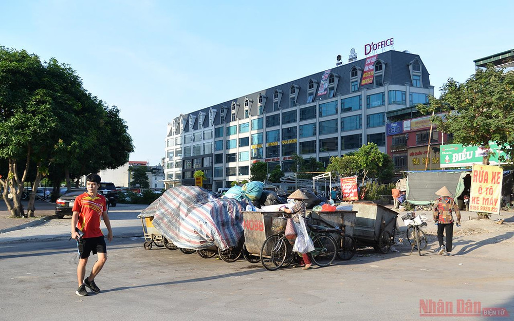 Khu vực phố Thành Thái (quận Cầu Giấy), một điểm tập kết rác sinh hoạt lộ thiên mà chưa được che chắn, rắc vôi bột hay phun hóa chất khử mùi. Ùn ứ rác thải tại nhiều khu vực nội thành Hà Nội -2