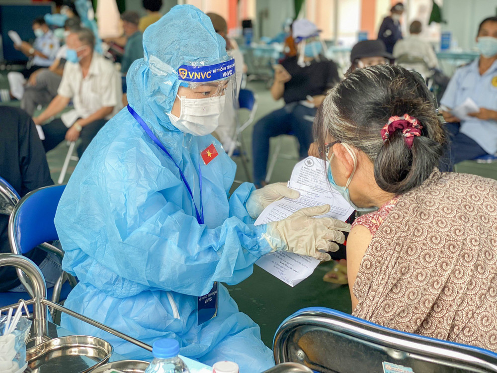 Nhân viên tiêm chủng tư vấn tận tình cho người dân. Tăng tốc tiêm chủng cho 300.000 công nhân, người dân Bình Dương -0