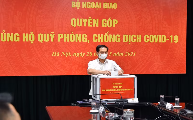 Bộ trưởng Ngoại giao Bùi Thanh Sơn quyên góp ủng hộ công tác phòng, chống dịch Covid-19. (Ảnh: Bộ Ngoại giao)