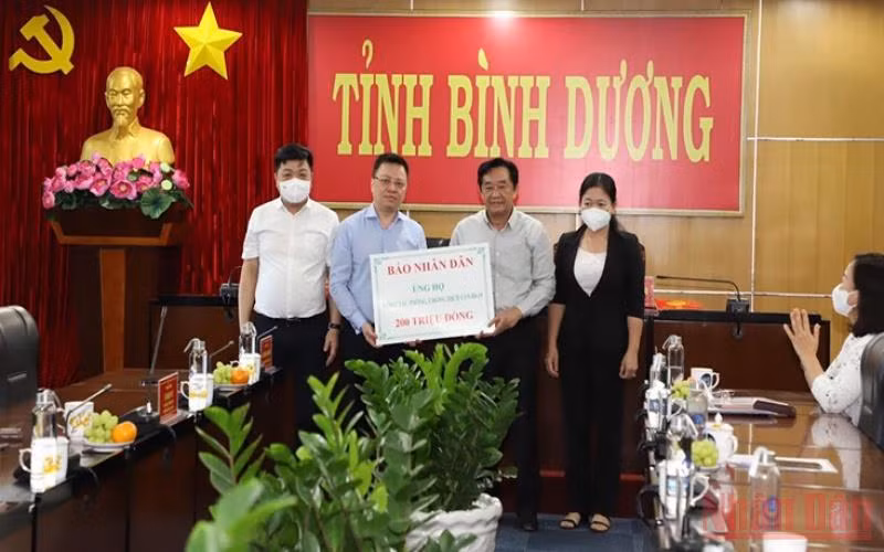 Tổng Biên tập Báo Nhân Dân Lê Quốc Minh trao 200 triệu đồng của Báo Nhân Dân ủng hộ tỉnh Bình Dương phòng, chống dịch bệnh Covid-19.