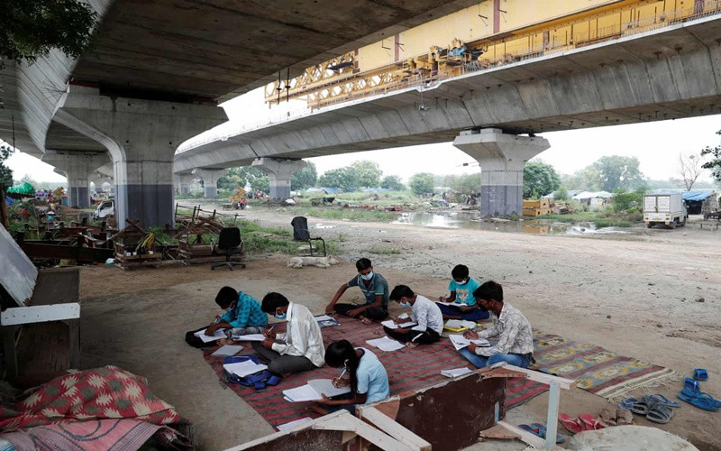 Đây là lớp học của các em học sinh sống trong khu nhà ổ chuột tại Delhi, Ấn Độ. Sau khi Chính phủ nước này đóng cửa toàn bộ trường học để ngăn chặn dịch Covid-19 lây lan, nhiều học sinh không có điều kiện học trực tuyến đã tham gia các lớp học được tổ chức ngoài trời. (Ảnh: Reuters) chaua1.jpg -0