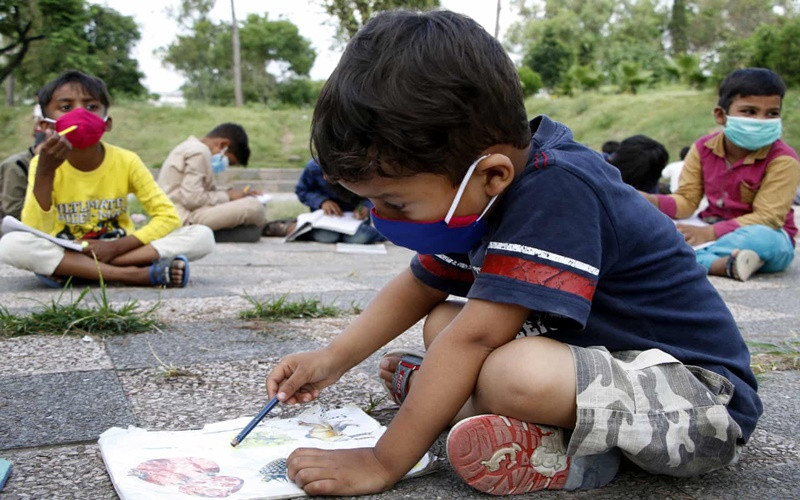 Các em nhỏ tham gia lớp học miễn phí ngoài trời tại thủ đô Islamabad, Pakistan. Lớp học kiểu này dành cho những trẻ em không thể đến trường. (Ảnh: EPA) 1 -0
