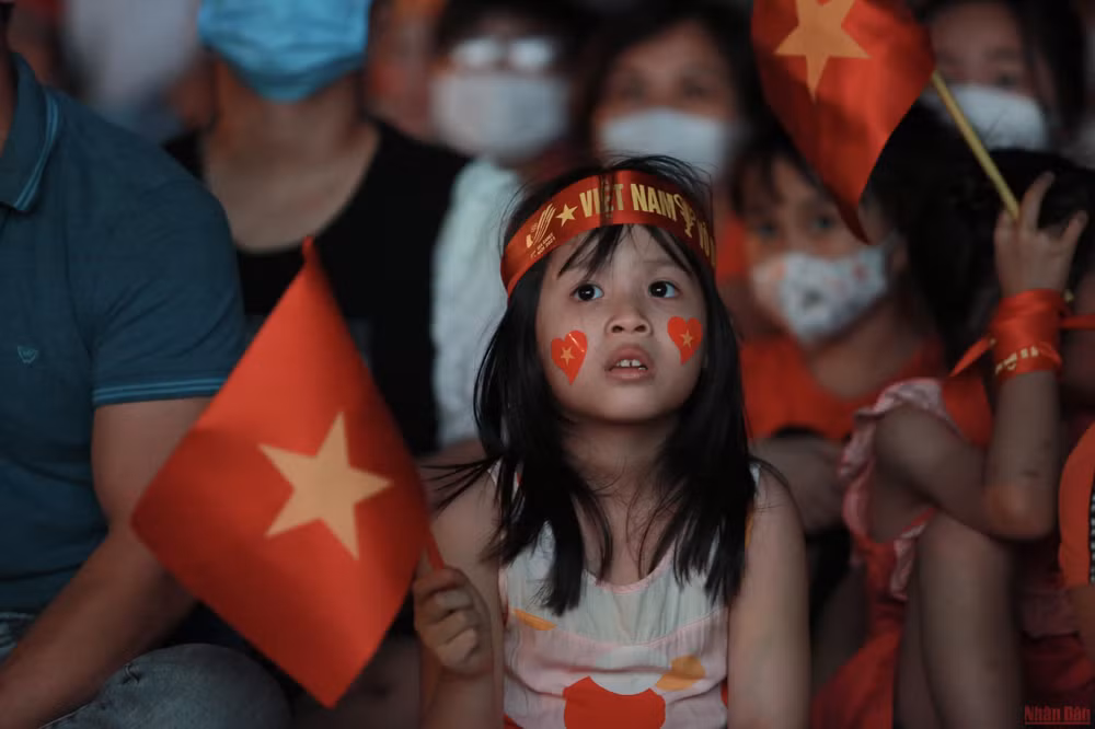 "Các chú cố lên! Con đang xem các chú đá đây!"