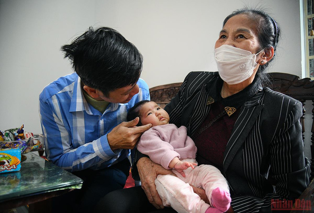 Bà Lan thì ngồi trên ghế, tay luôn ôm chặt đứa cháu nội mới hơn 2 tháng tuổi từ lúc về đến nhà. (Ảnh: THÀNH ĐẠT) Đồng bào trở về từ Ukraine: Chuyến hồi hương hạnh phúc nhất -0