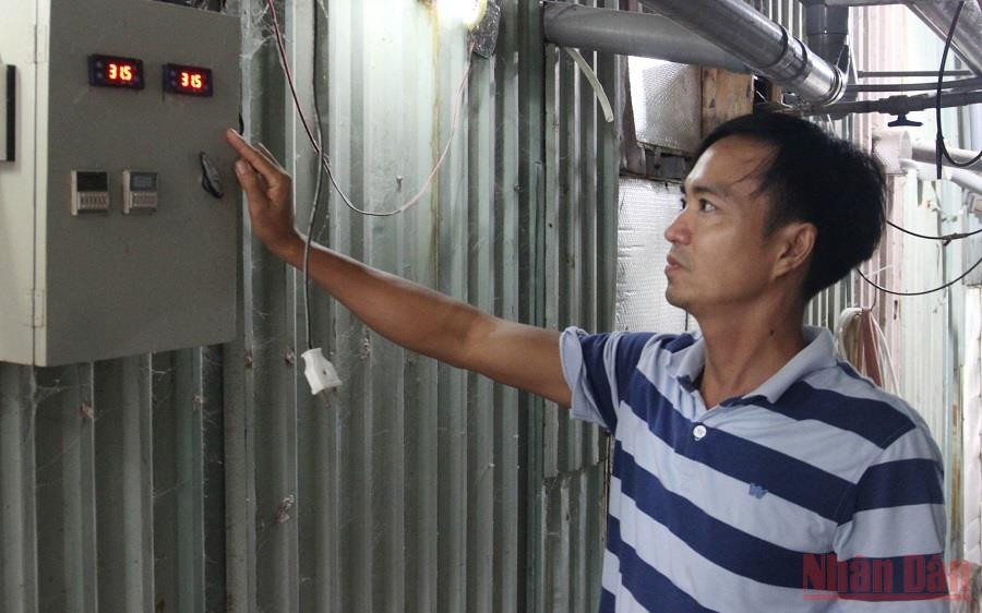 Anh Tùng giới thiệu về hệ thống máy móc và máy báo nhiệt độ mỗi phòng. (Ảnh: THANH TÂM) Trồng nấm rơm công nghệ cao ổn định mùa dịch -0