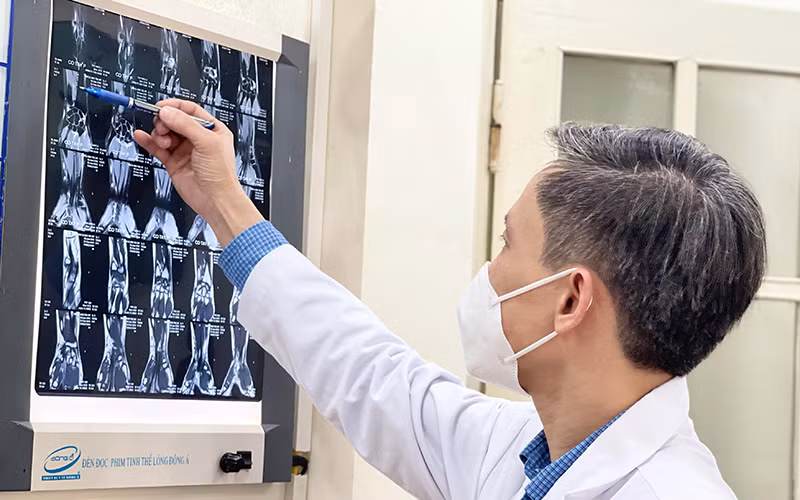 PGS,TS Nguyễn Mạnh Khánh xem hình ảnh MRI của bệnh nhân trước khi tiến hành phẫu thuật nội soi. 