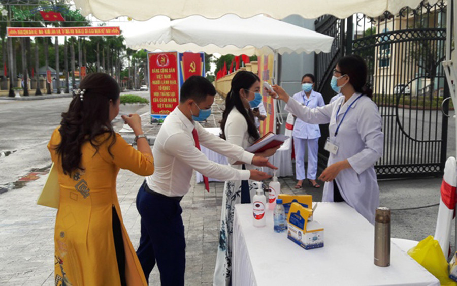 Công chức, viên chức ở Thanh Hóa rửa tay, được kiểm tra thân nhiệt trước khi tham dự sự kiện đông người.