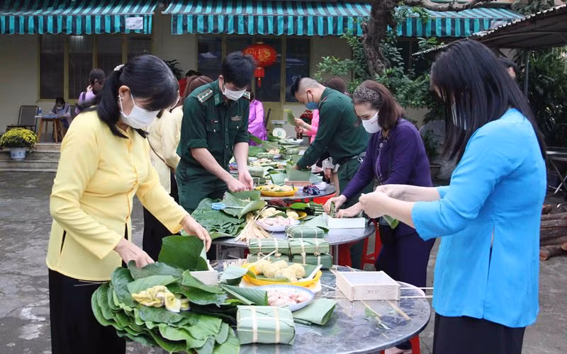 Cùng các chiến sĩ bộ đội biên phòng gói bánh chưng.