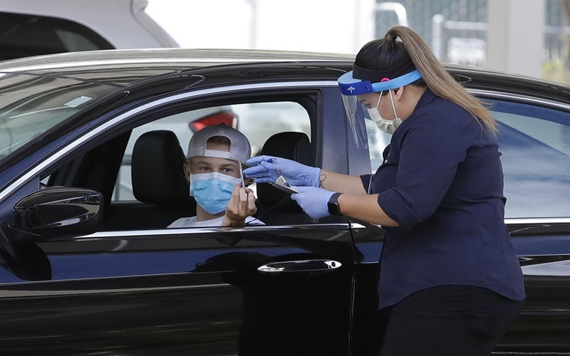 Nhân viên y tế thu thập thông tin của người dân tại một trung tâm xét nghiệm Covid-19 ở California, Mỹ, ngày 21-7. (Ảnh: AP)