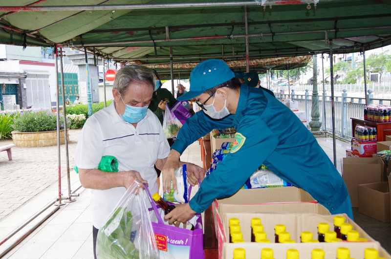 Hỗ trợ người dân nhận nhu yếu phẩm tại “Phiên chợ 0 đồng”. Sát cánh cùng các địa phương phía nam chống dịch -0