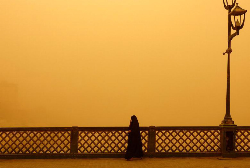 Người phụ nữ đi bộ trên cây cầu tại Baghdad trong trận bão cát ngày 23/5. Bão cát Iraq -0