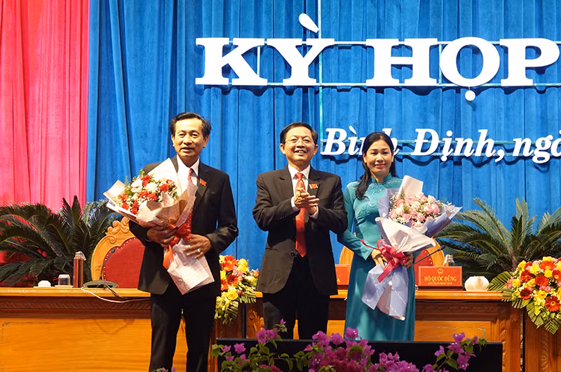 Ông Hồ Quốc Dũng, Ủy viên Ban Chấp hành Trung ương Đảng, Bí thư Tỉnh ủy, Chủ tịch Hội đồng nhân dân tỉnh (đứng giữa) tặng hoa chúc mừng hai Phó Chủ tịch Hội đồng nhân dân tỉnh Bình Định khóa XIII, nhiệm kỳ 2021 – 2026.