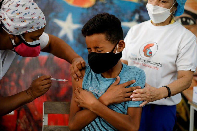 Tiêm vaccine ngừa Covid-19 cho học sinh ở Caracas, Venezuela, ngày 27/10/2021. (Ảnh: Reuters) Tín hiệu tích cực trong cuộc chiến chống đại dịch Covid-19 toàn cầu -0