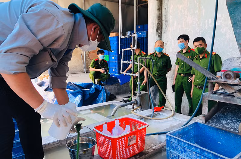 Nhân viên Sở Tài nguyên và Môi trường Đồng Nai lấy mẫu nước thải khu vực để máy nghiền bóng đèn thải.