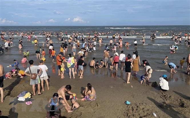 Bãi biển Sầm Sơn đông kín người. (Ảnh: Nguyễn Nam/TTXVN) Hoạt động du lịch khắp 3 miền sôi động trong dịp nghỉ lễ 30/4 và 1/5 -0