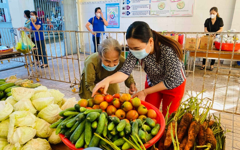 Cô Mạch Lệ Xuân, Hiệu trưởng Trường tiểu học Ngô Quyền dìu cụ bà lựa chon rau quả tại chợ “0 đồng”. CT6-1624260532136.jpg