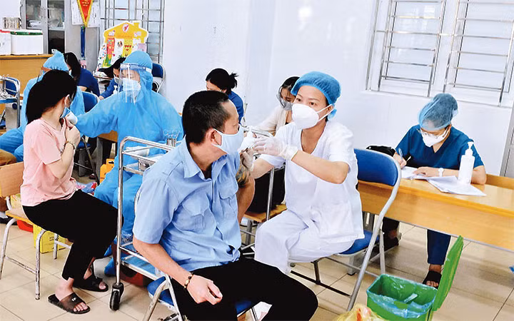 Tiêm vắc-xin phòng Covid-19 mũi 3 cho người dân tại phường Vĩnh Hưng, quận Hoàng Mai, Hà Nội. (Ảnh: ĐĂNG KHOA)