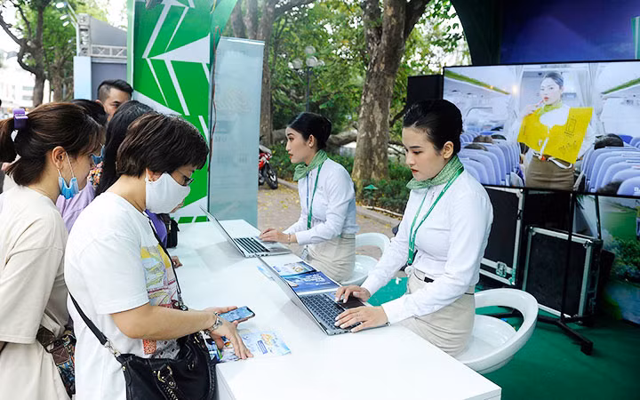 Khách hàng đặt mua vé máy bay trên điện thoại di động tại lễ hội du lịch và văn hóa ẩm thực Hà Nội năm 2021 - ảnh chụp trước khi dịch Covid-19 bùng phát lần thứ tư. (Ảnh: ANH SƠN)