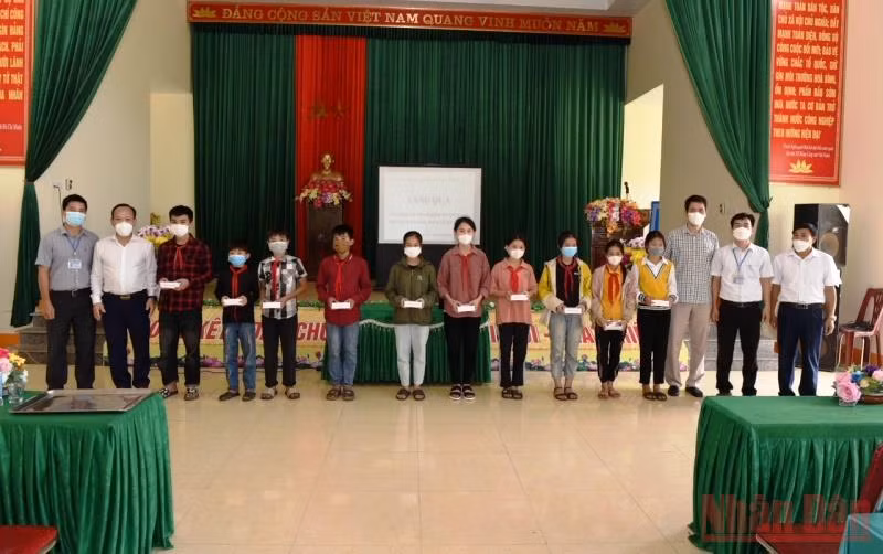 Đại diện lãnh đạo huyện Quỳ Hợp và phóng viên Báo Nhân Dân thường trú tại Nghệ An trao điện thoại thông minh cho các cháu học sinh nghèo hiếu học. 