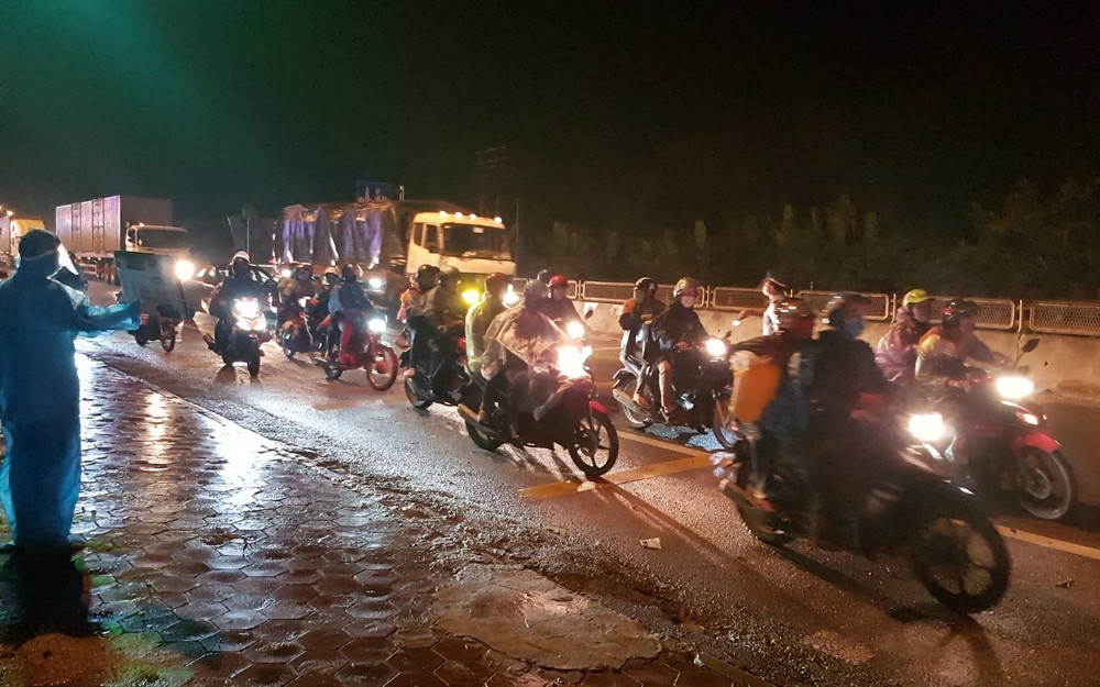 Đoàn xe máy của người dân di chuyển về quê qua chốt kiểm dịch dốc Xây (Ninh Bình).