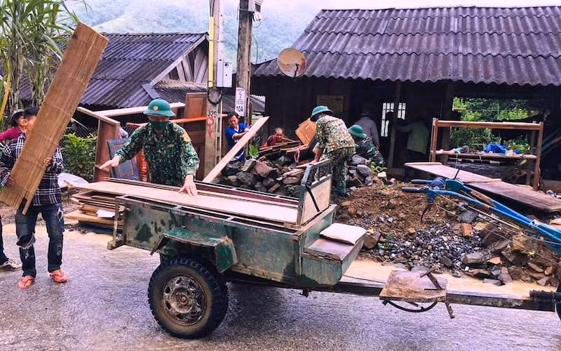 Bộ đội biên phòng trợ giúp hộ dân vận chuyển đồ dùng, vật dụng đến nơi ở mới.