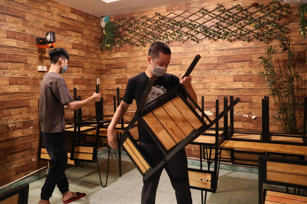 Từ sáng sớm, các nhân viên đã tất bật lau dọn bàn ghế, xếp vách ngăn phòng dịch chuẩn bị đón khách trong ngày đầu được phép mở lại. 4_hang_quan_Ha_Noi_mo_cua-1624331437505.jpeg