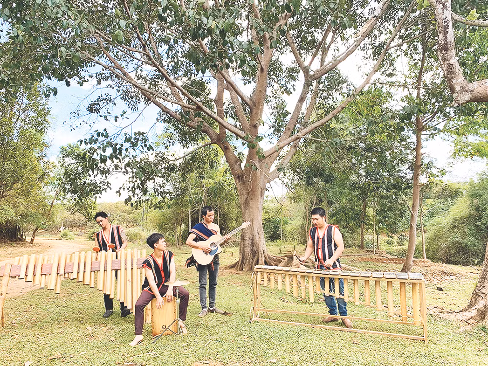 Rơ Châm Khánh (bên phải) cùng các bạn trẻ diễn tấu nhạc cụ truyền thống kết hợp hiện đại.