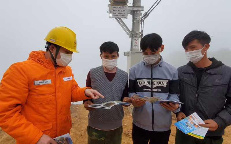 Cán bộ Điện lực Sơn La hướng dẫn người dân xã Chiềng Kheo cách sử dụng điện tiết kiệm.