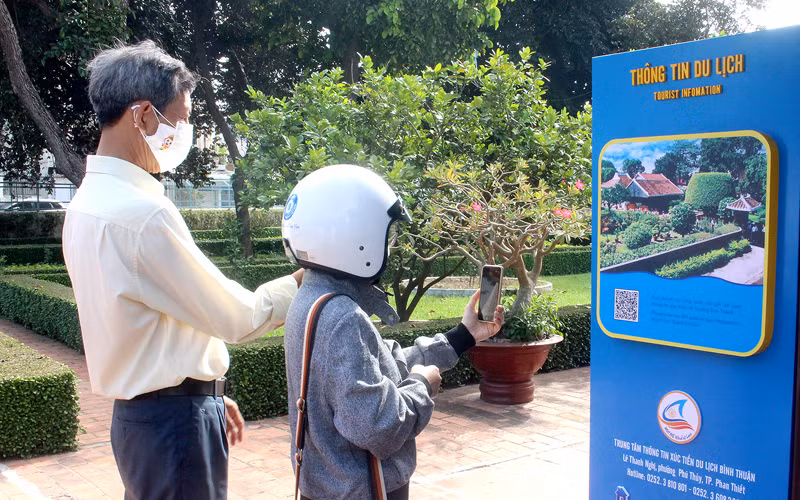 Người dân trải nghiệm quét mã QR tại một điểm tham quan. 