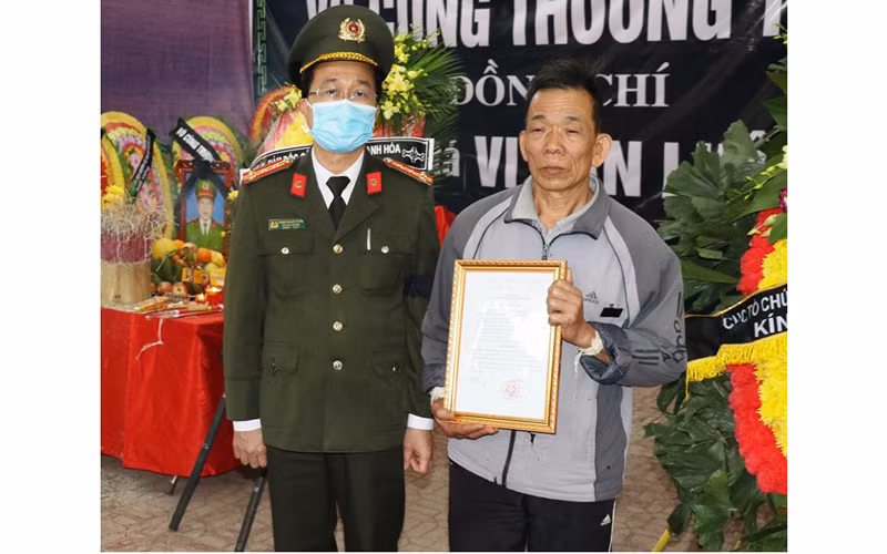 Thừa ủy quyền của Bộ trưởng Công an, lãnh đạo Cục Tổ chức - Cán bộ trao tới gia đình Quyết định thăng cấp bậc hàm trước niên hạn cho đồng chí Vi Văn Luân.